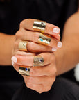 Model wearing the Reptilia gold ring with natural gemstone, on-hand view.