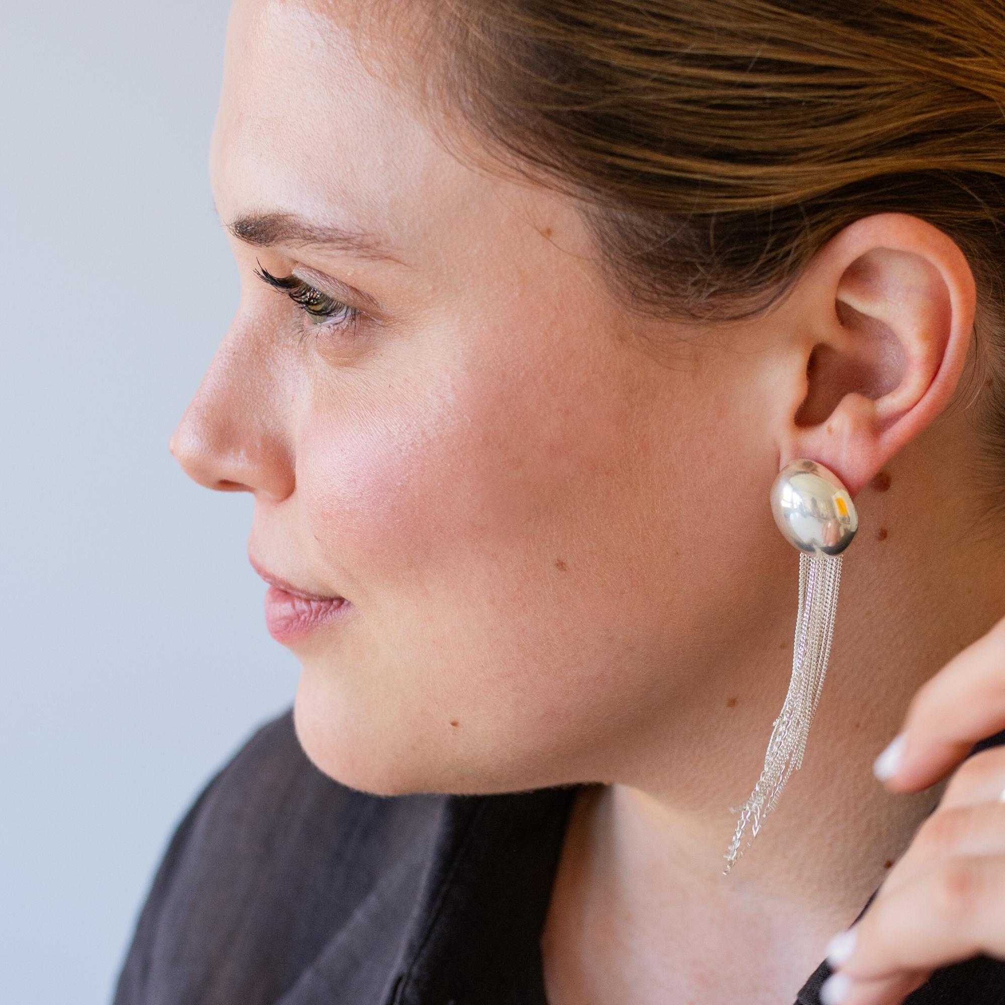 NOCTURNE earring add-on worn behind a stud earring, creating a striking silhouette with fine chains
