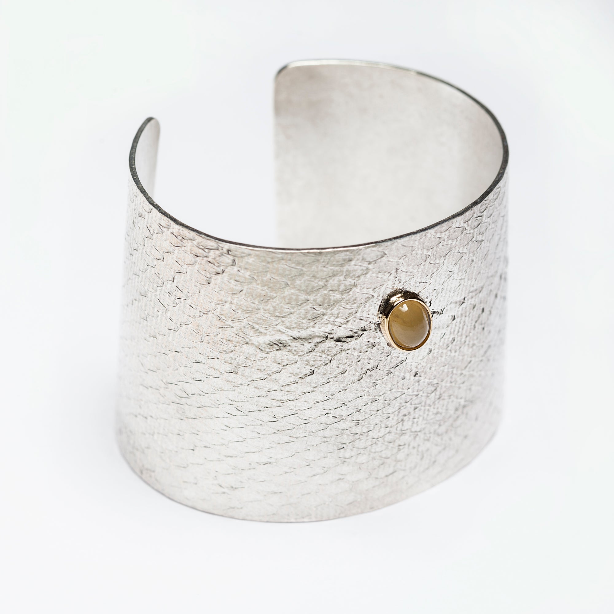 Reptilia Maxima silver cuff with yellow aragonite cabochon, angled front view.