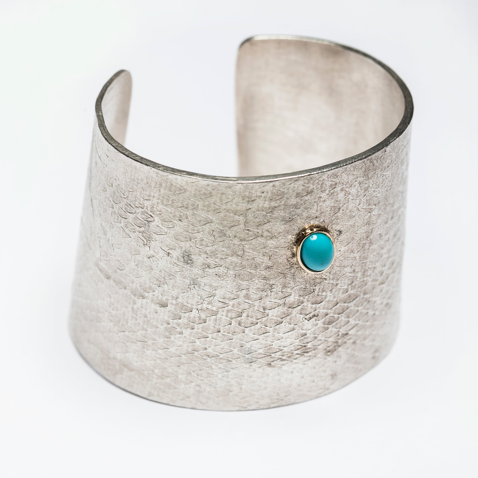 Reptilia Maxima silver cuff with turquoise cabochon, angled front view.